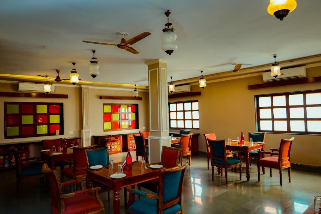 Royal Dining Hall featuring hand-crafted stained-glass windows, brass chandeliers, and vibrant royal wooden chairs