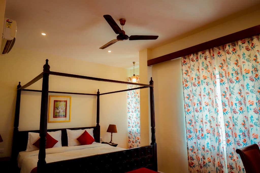Executive Room four-poster bed with floral drapes